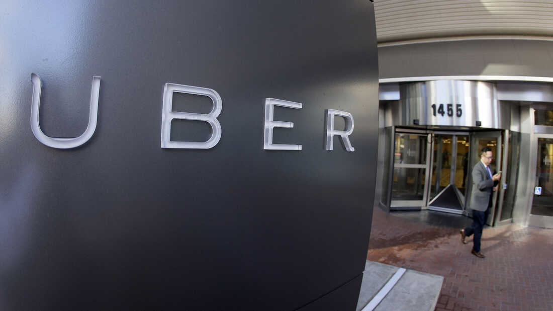 A man leaves Uber's headquarters in San Francisco. The company has been fighting a class action lawsuit brought against it by drivers for three years.