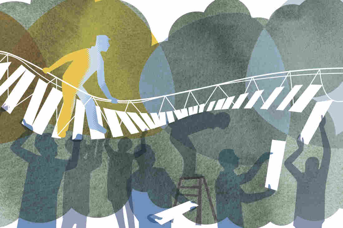 Man walking on bridge supported by co-workers below