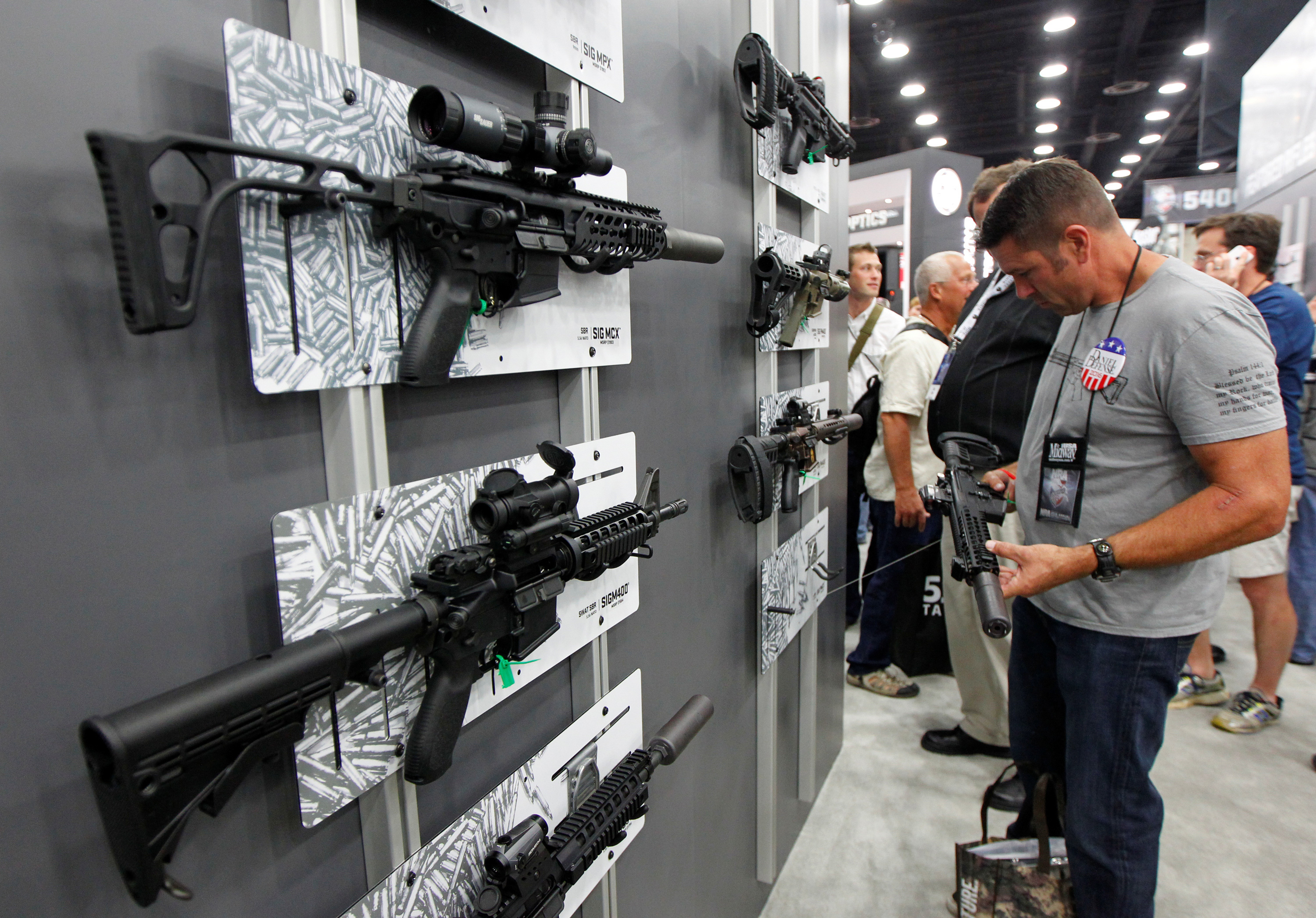 A Sig Sauer MCX rifle can be seen on display at the top left of this photo as NRA gun enthusiasts view the Sig Sauer display at the National Rifle Association's annual meetings & exhibits show in Louisville, Ky., in May. (Reuters)