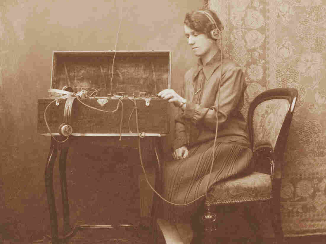 A woman uses a Morse code device housed within an oak box.