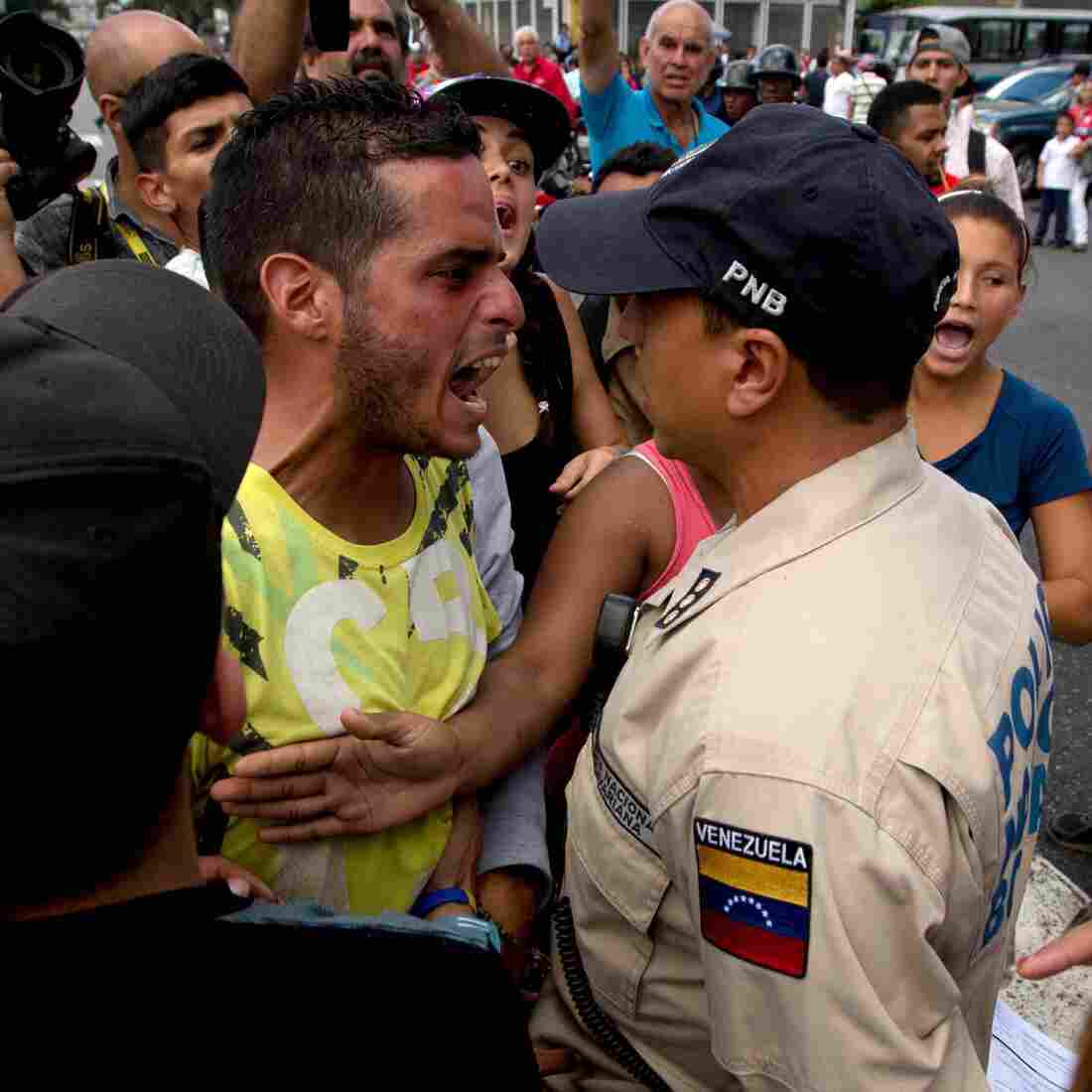 An angry man outside a grocery store argues with a policeman in Caracas, Venezuela, on June 8 amid the country's ongoing food shortages. After waiting for hours, customers began protesting, an increasingly common occurence in Venezuela, which is suffering a severe economic crisis. An angry man outside a grocery store argues with a policeman in Caracas, Venezuela, on June 8 amid the country's ongoing food shortages. After waiting for hours, customers began protesting, an increasingly common occurence in Venezuela, which is suffering a severe economic crisis.