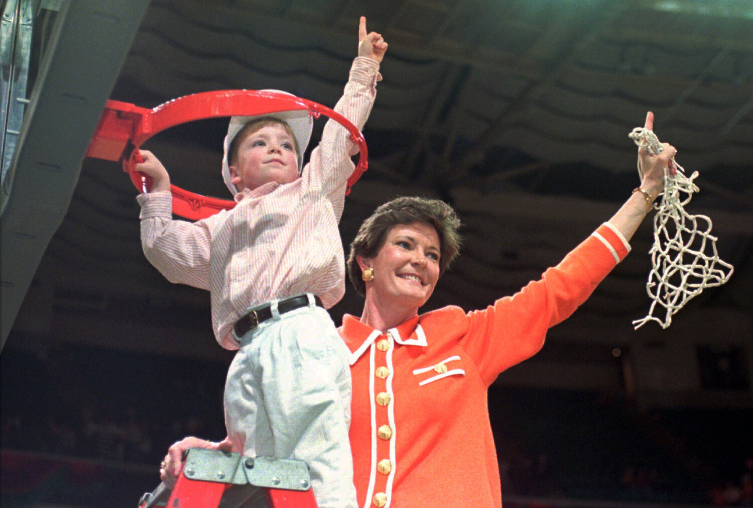 Tennessee coach Pat Summitt and son Tyler, 5, take down the net after the Lady Vols won the NCAA women's Division I title in Charlotte, N.C, on March 31, 1996.
