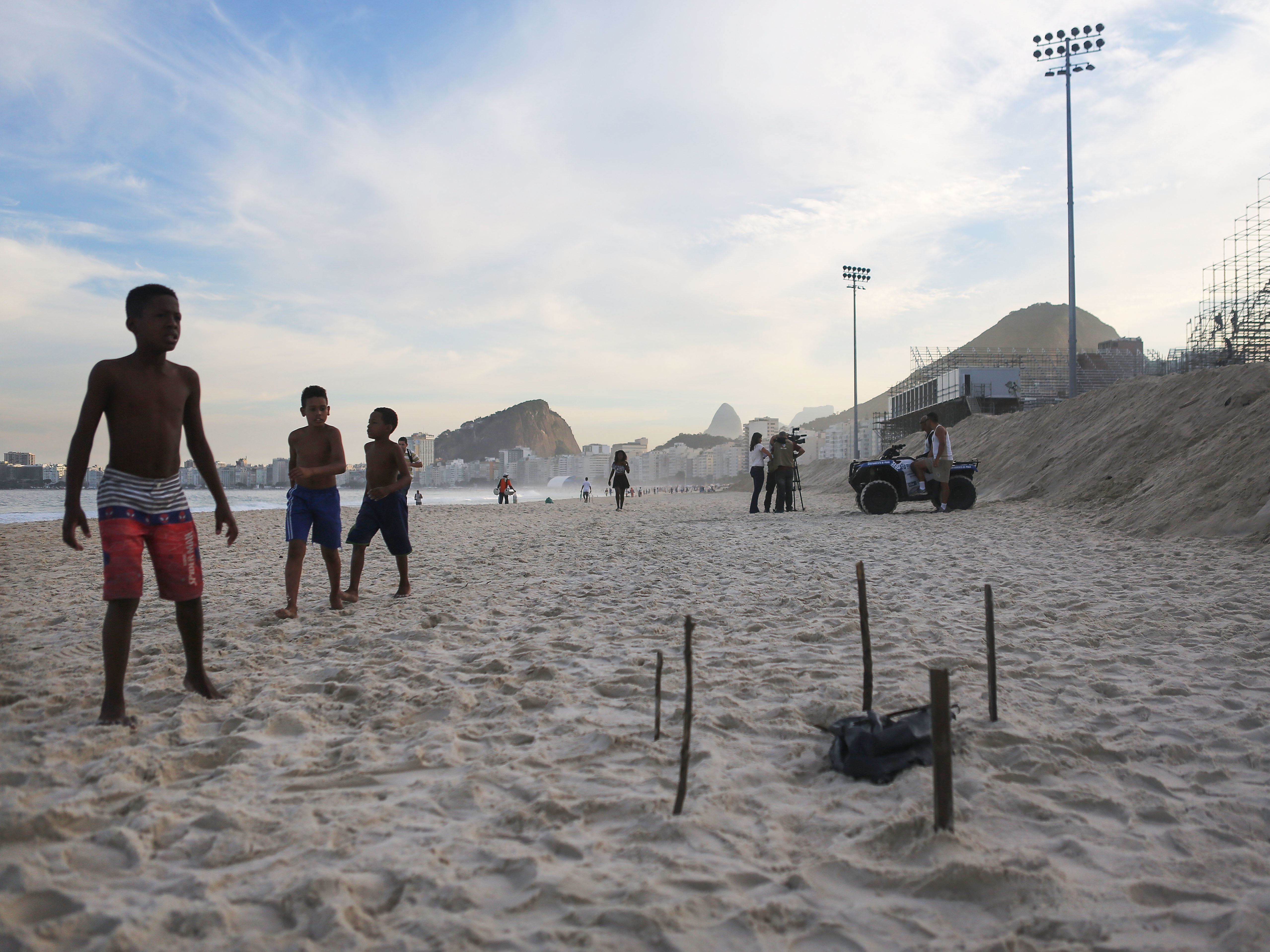 Young beachgoers walk near a body part covered in a plastic bag, which was discovered on Rio's Copacabana Beach near the Olympic beach volleyball venue on Wednesday. The Rio 2016 Olympic Games begin August 5.