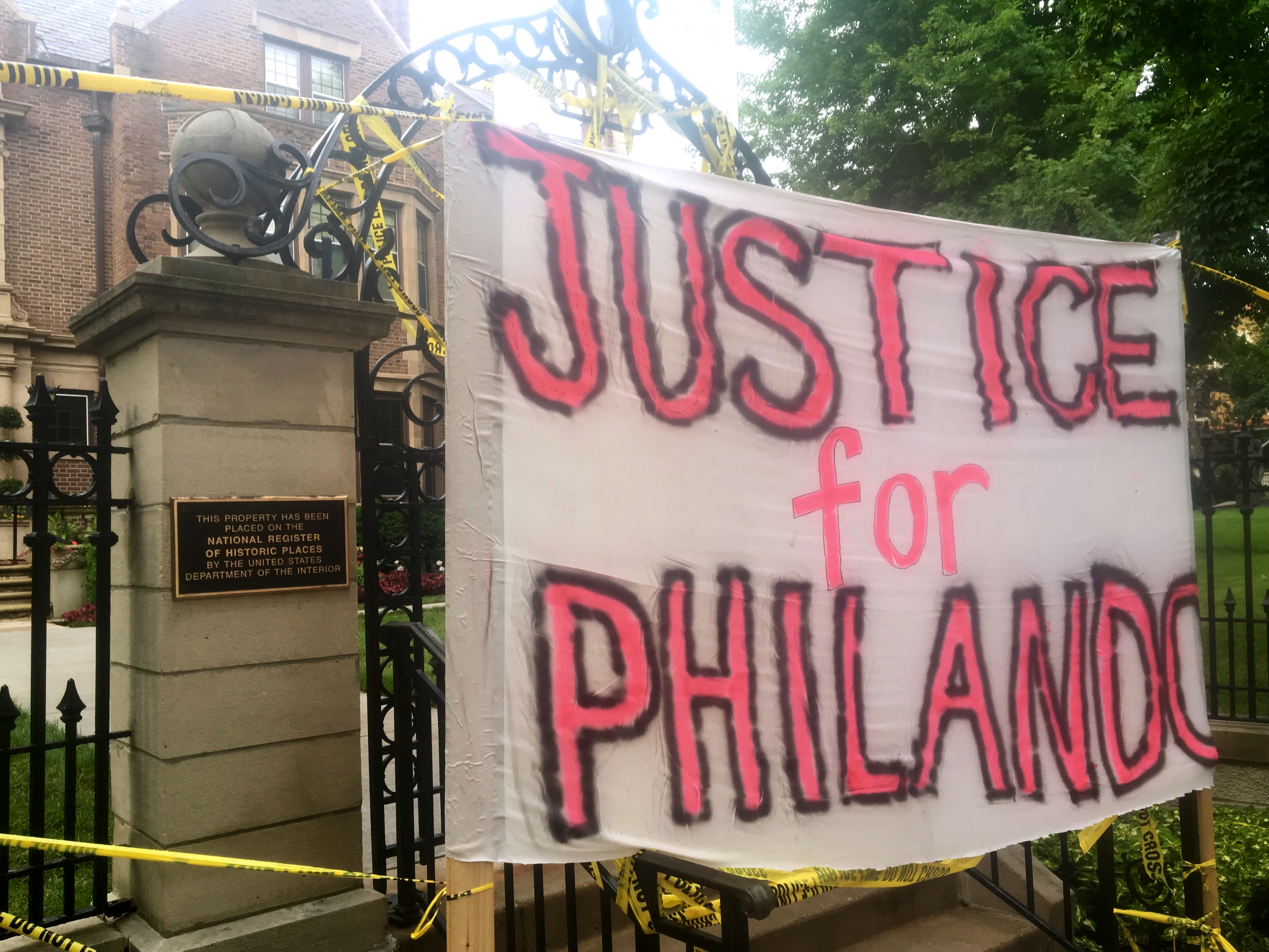 A sign is hung outside the Minnesota Governor's Residence as about 200 people gathered in St. Paul on Thursday, protesting the fatal shooting of Philando Castile by a suburban police officer.