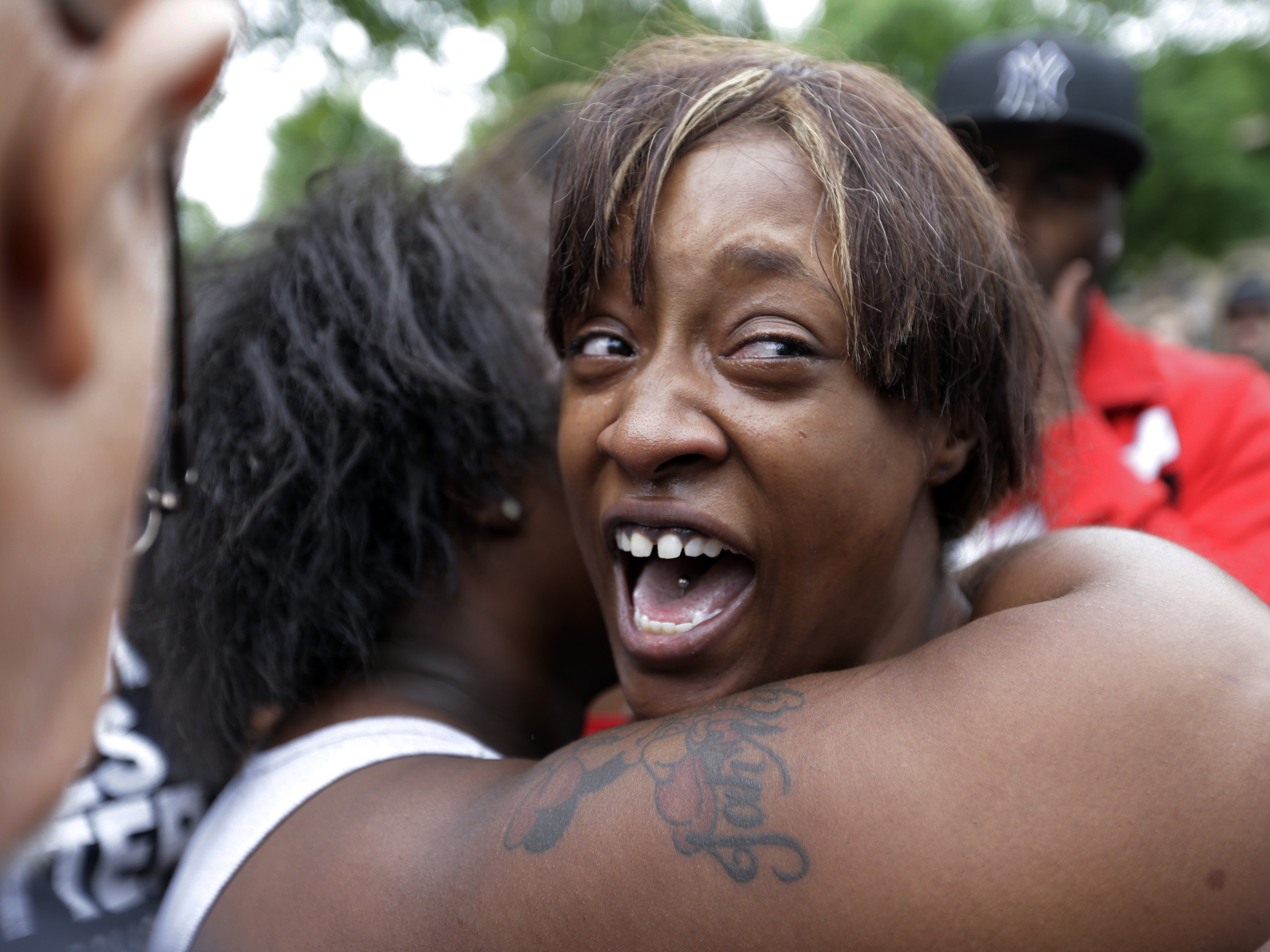 Diamond Reynolds, the girlfriend of Philando Castile, is consoled as she talks about his shooting death with protesters and media outside the governor's residence in St. Paul, Minn.