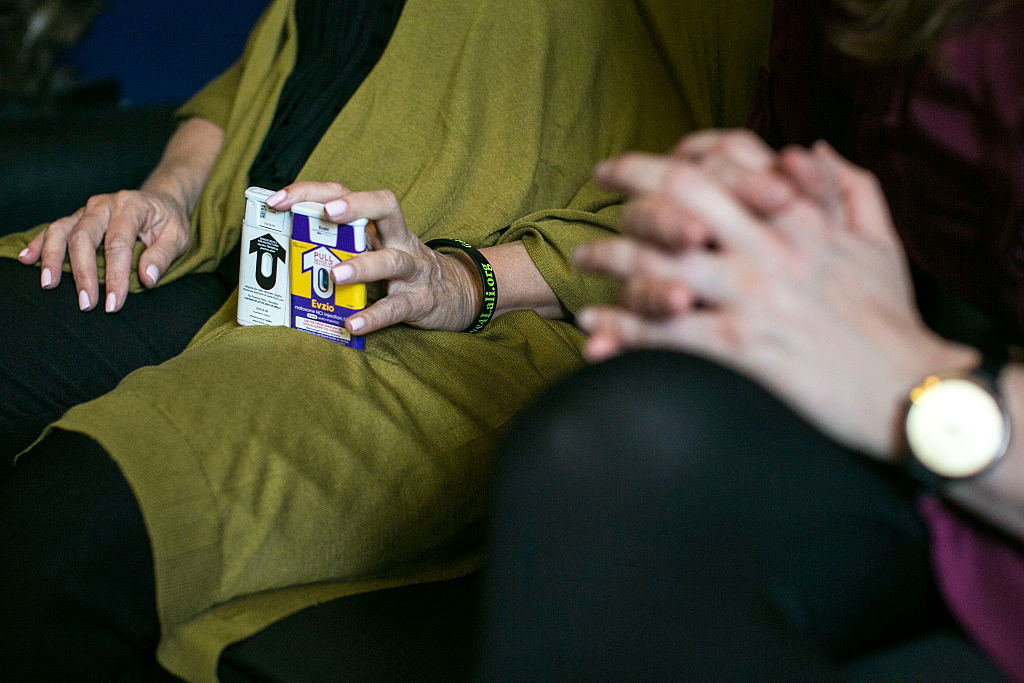 A woman lobbying Congress holds two versions of naloxone, also known as Narcan, which can be used to reverse an opioid overdose.