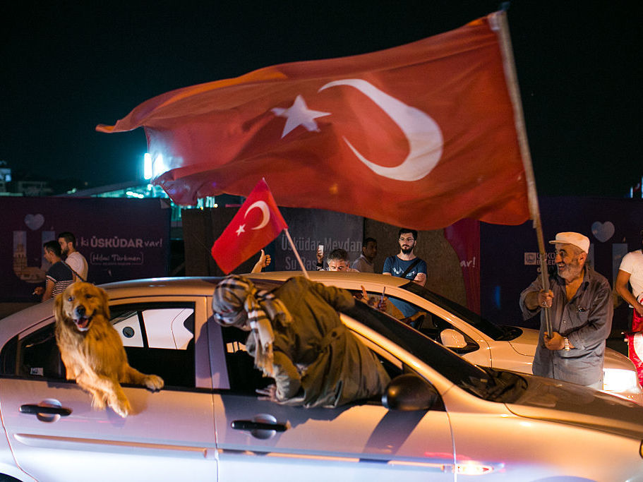 People drive next to a Turkish man waving a flag in Uskudar district in Istanbul on July 16 during a demonstration in support of Turkey's president.