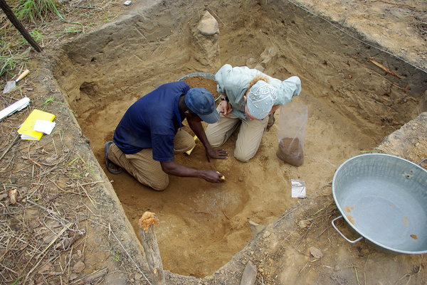 Grains, beads and bangles unearthed from dig sites in Banda, Ghana, tell of a time when droughts did not bring famine. (Above) Archaeologists Amanda Logan and Osei Kofi dig into the floor of a house from the 1500s.