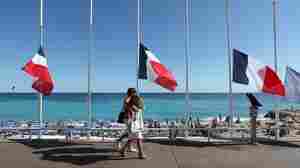 French flags are seen lowered at half-staff in Nice on July 16. The truck attack on July 14 killed 84 people. "I felt coming to celebrate on holiday and people are in mourning didn't seem right," one vacationer says. "But I'm glad I came."