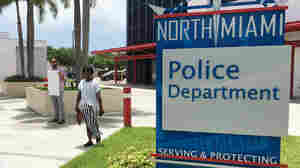 Gabriel Pendas (left) protests outside the North Miami Police Department on Thursday. The department held a news conference about the police shooting of a black behavioral therapist helping a man with autism.