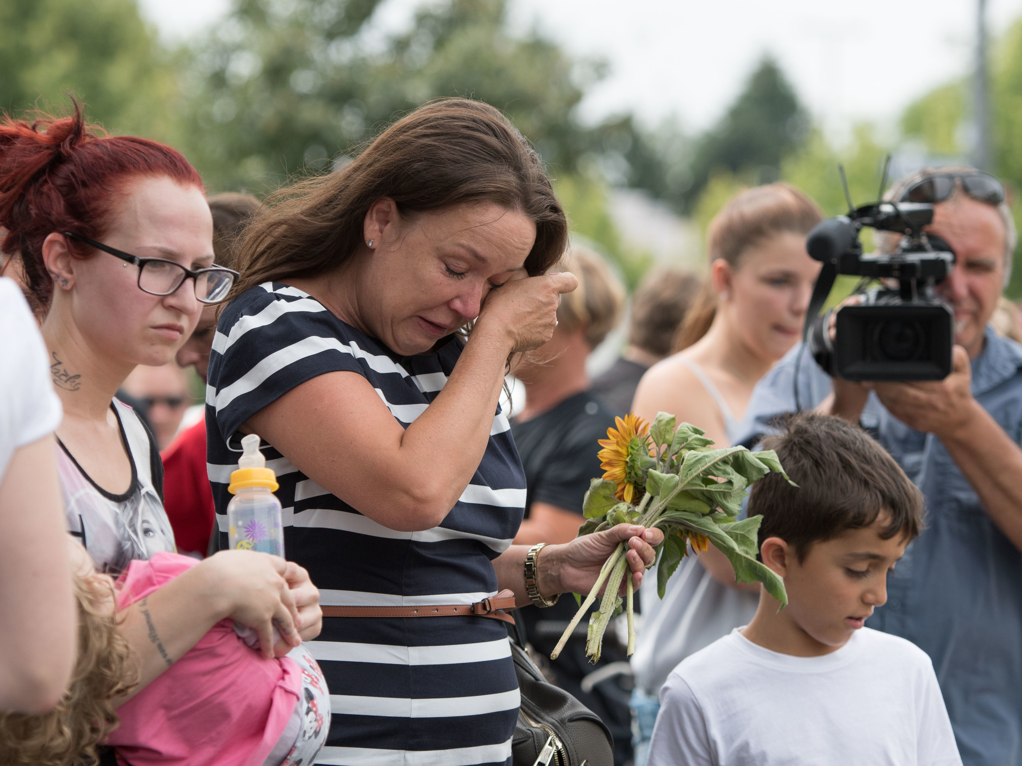 A woman cries at a make shift memorial site on Saturday near the Olympia shopping center where a shooting took place leaving nine people dead the day in Munich, Germany.