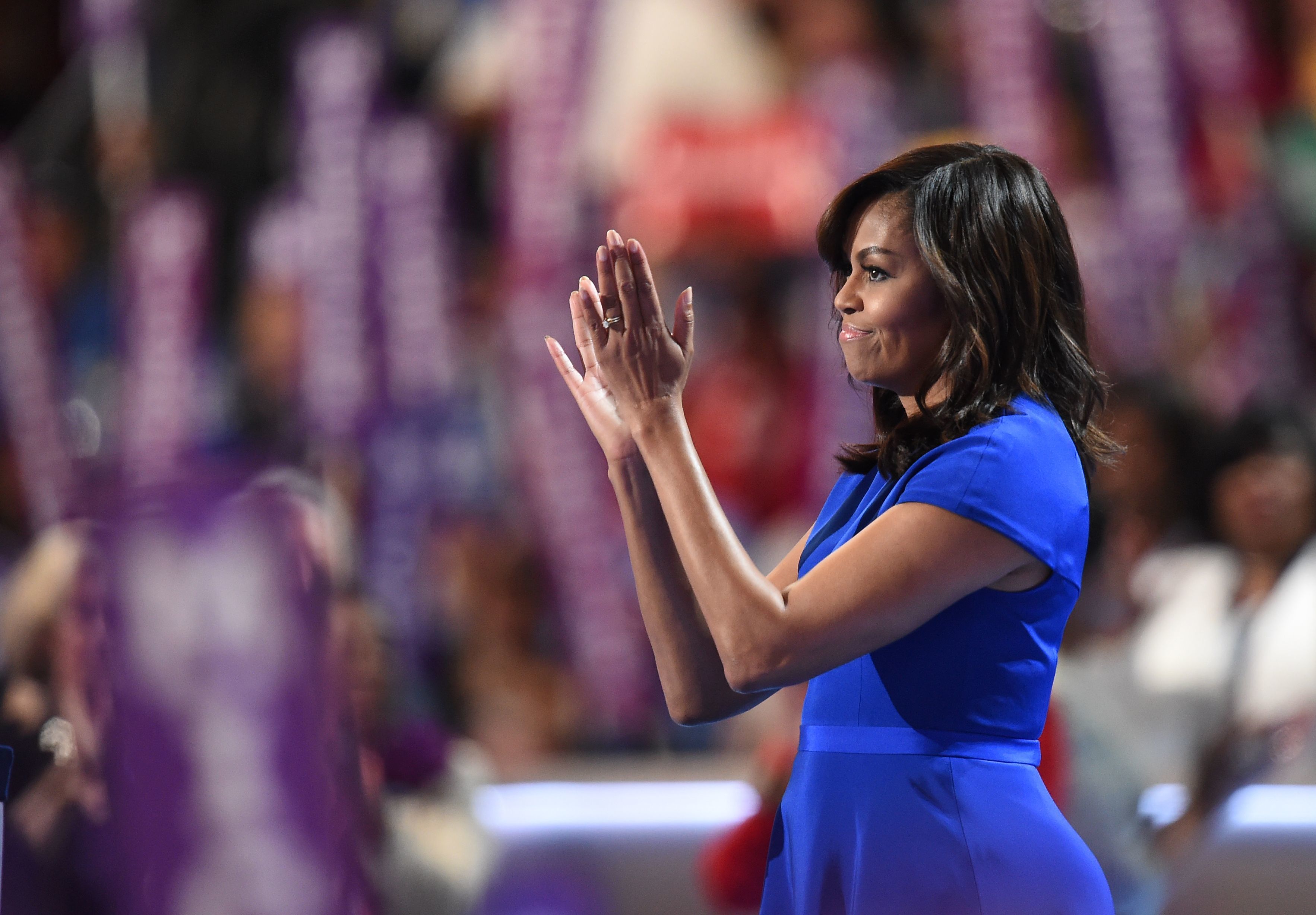 First Lady Michelle Obama applauds from the stage after addressing delegates on the first day of the Democratic National Convention in Philadelphia.