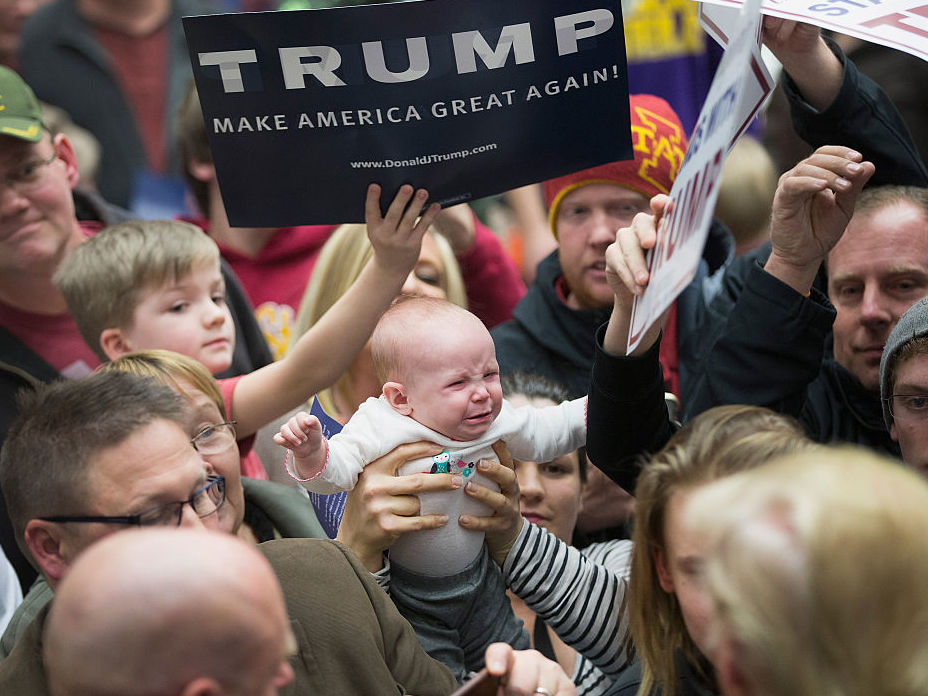 A woman tries to get her baby kissed by Republican presidential candidate Donald Trump at a Jan. 26 Iowa rally. (Getty Images)