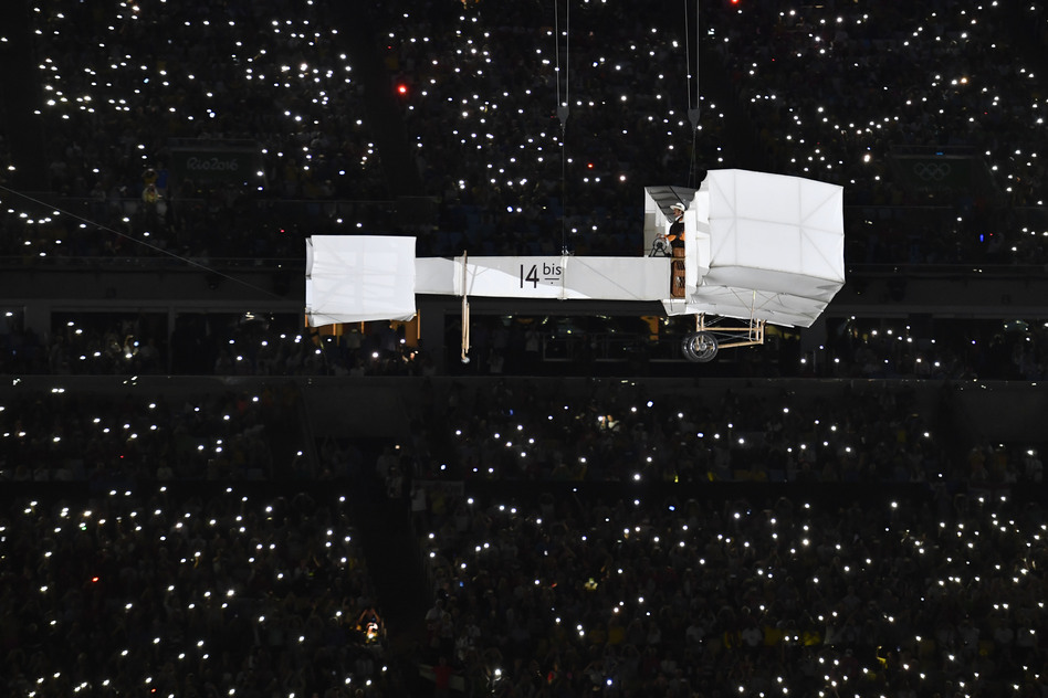 A wright-brothers style aircraft forms part of the opening ceremony flown by a gentleman in old-fashioned clothes. (Getty Images)
