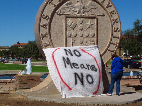 Texas Tech freshman Regan Elder helps drape a bed sheet with the message "No Means No" over the university's seal at the Lubbock, Texas campus in 2014 to protest what students say is a "rape culture" on campus.