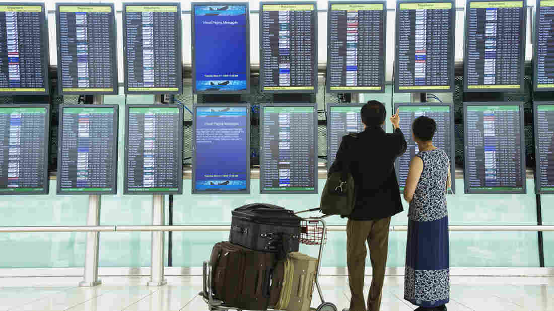A couple checks flight schedules.