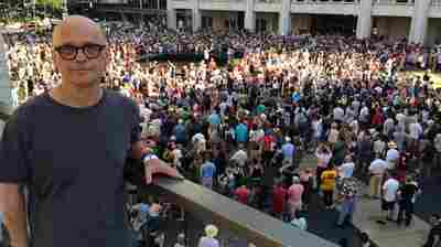 Pulitzer Prize-winning composer David Lang on the balcony of David Geffen Hall while 1,000 people gathered below him on the Lincoln Center Plaza, in New York to sing one of his new pieces.