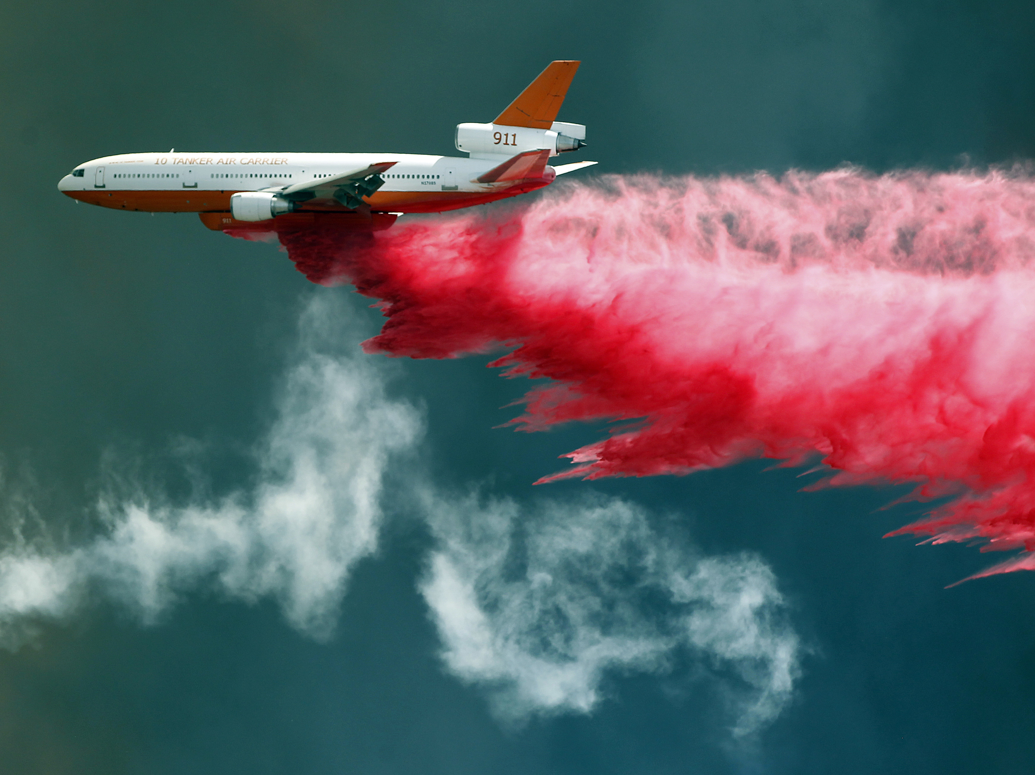 An air tanker fights California's Bluecut wildfire with flame retardant. Fire experts say Bluecut has burned and spread with a ferocity they've never seen before.