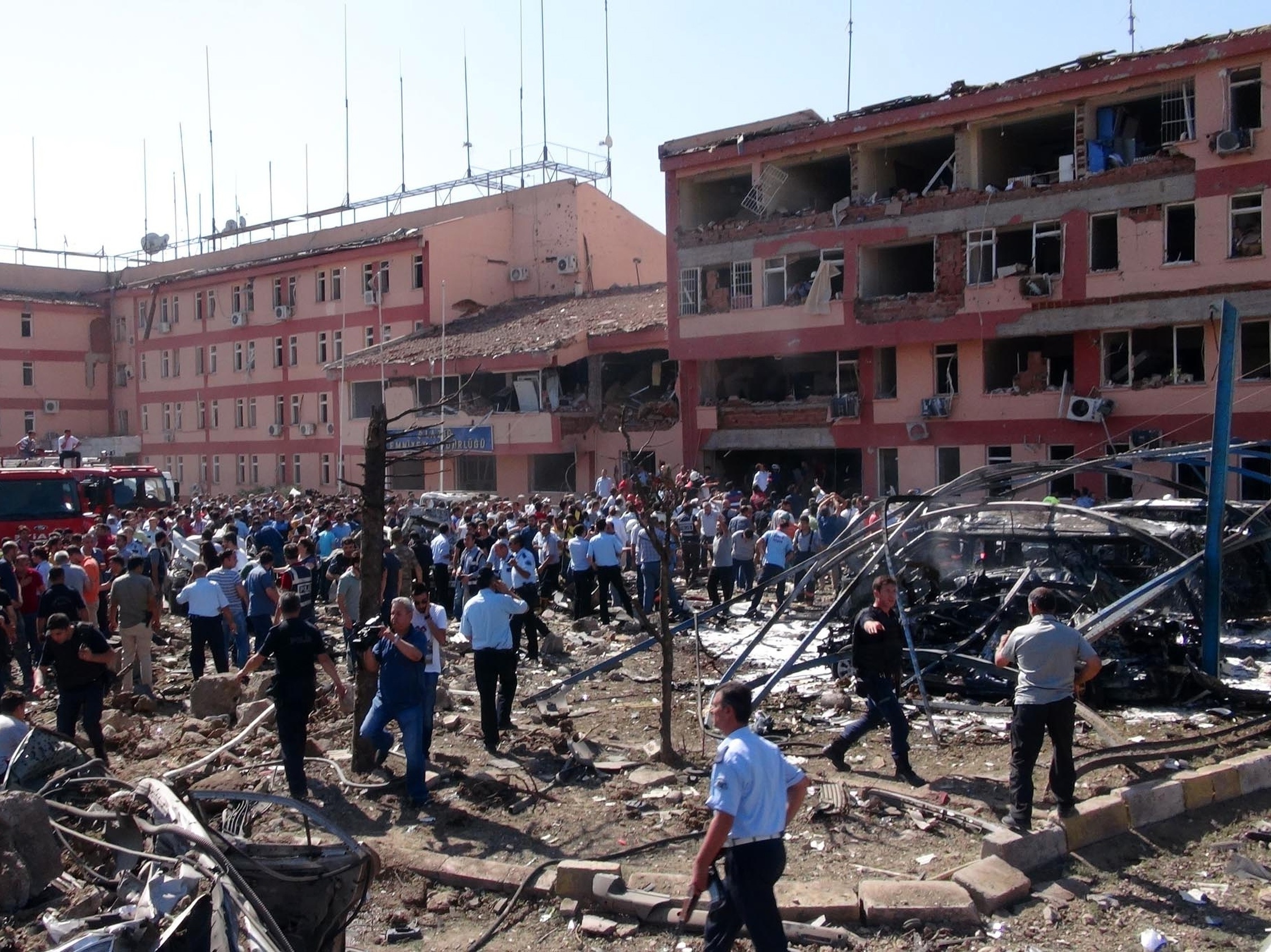 Turkish authorities search outside a damaged building after an explosion in Elazig, eastern Turkey, on Thursday. Two car bombings targeted police stations in Turkey, killing a number of people and wounding hundreds, officials said.