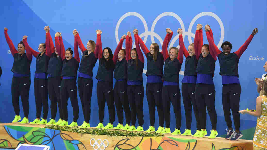 Gold medal winners on the U.S. women's water polo team celebrate on the podium after beating Italy in Rio de Janeiro Friday.