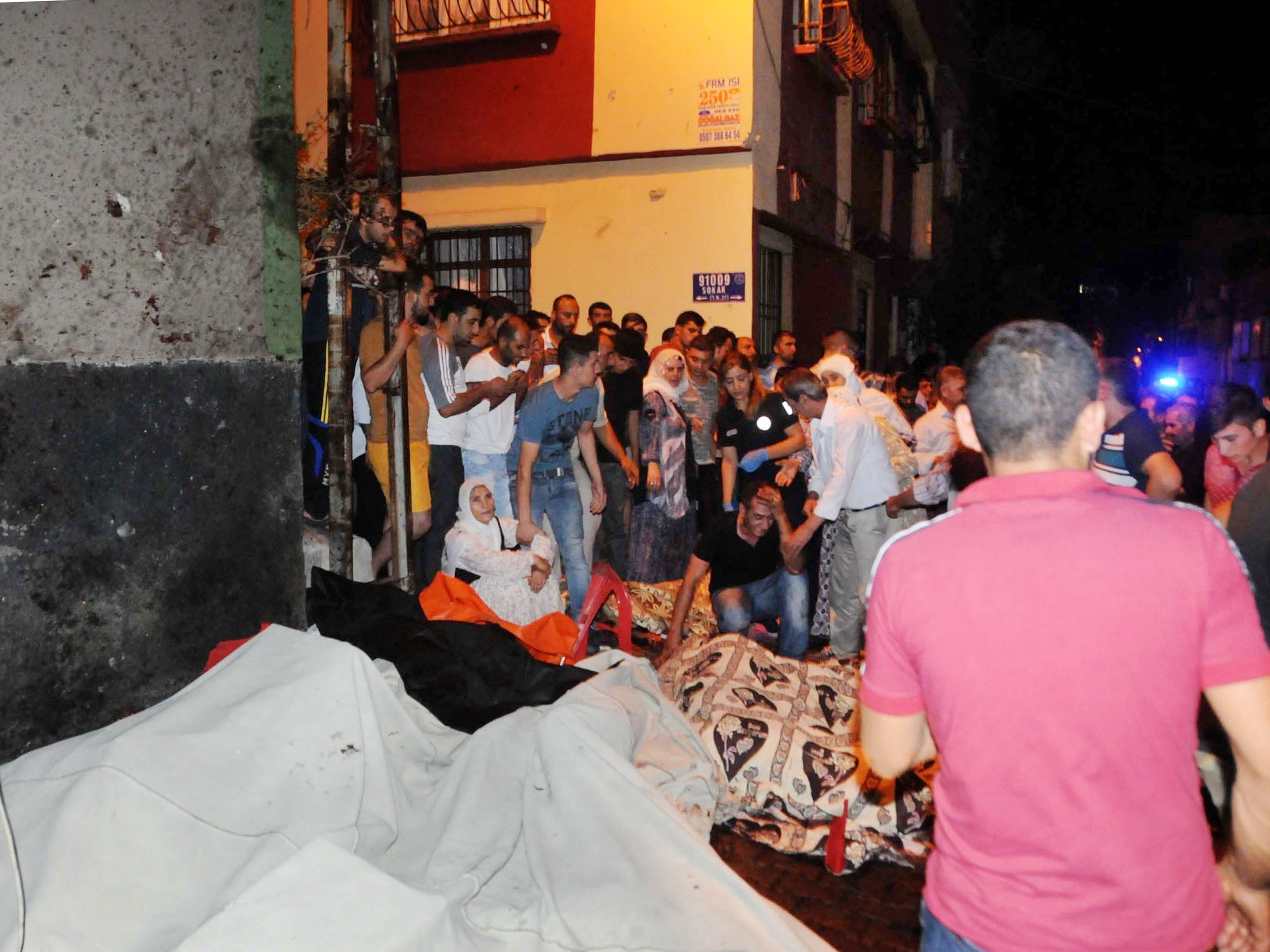 People react after an explosion in Gaziantep, southeastern Turkey. Gaziantep province Gov. Ali Yerlikaya said the deadly blast, during a wedding near the border with Syria, was a terror attack.