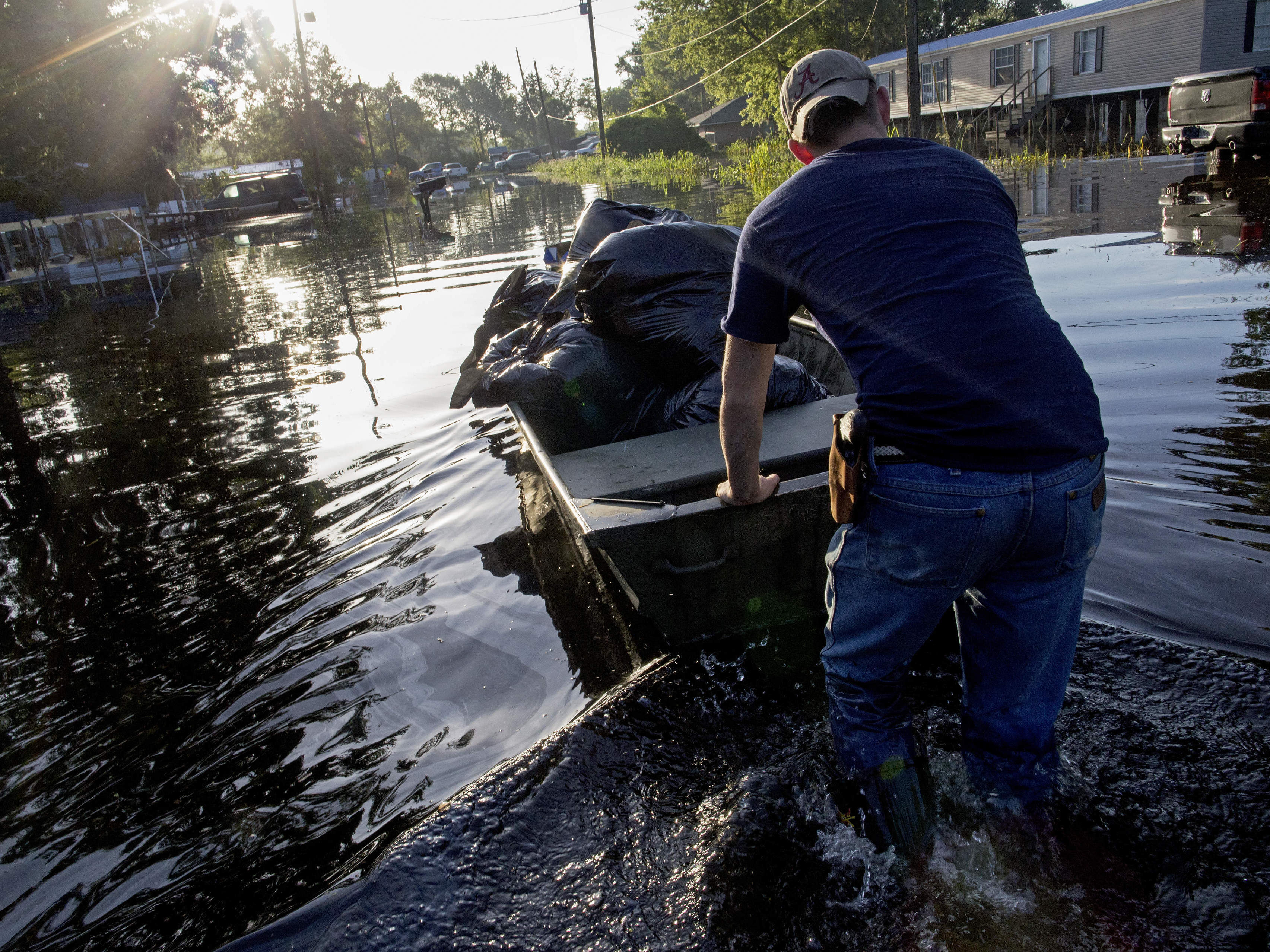 Daniel Stover, 17, moves a boat of personal belongings from a friend's flooded home in Sorrento, La., on Saturday.