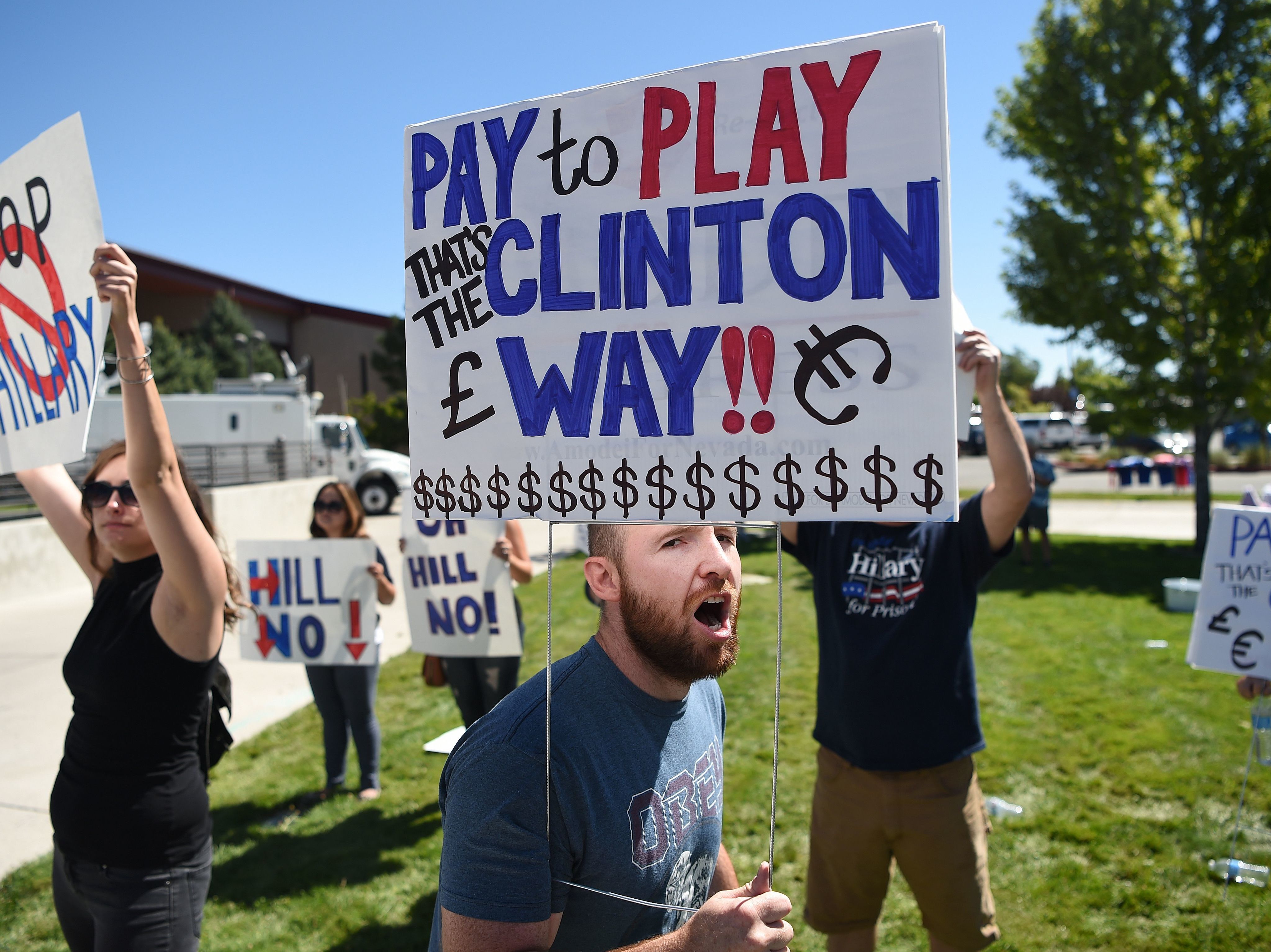 Protesters shout as people wait to enter a Hillary Clinton campaign event last month in Nevada. Donald Trump is calling for a special prosecutor to investigate allegations of pay-to-play by Clinton, but the history of independent counsels and special prosecutors suggests they don't always remove politics from the process.