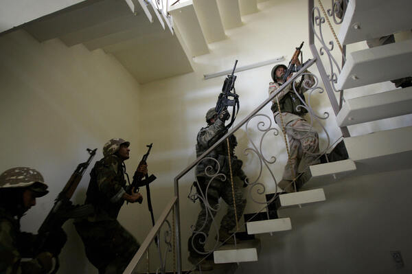 U.S. soldiers and Iraqi national police race up a staircase as they search a house in Baghdad in 2007. The U.S. surge in Iraq drove back Islamist radicals at that time. The gains were lost after the U.S. withdrew from Iraq in 2011, but the Americans have returned with an air campaign against the Islamic State.