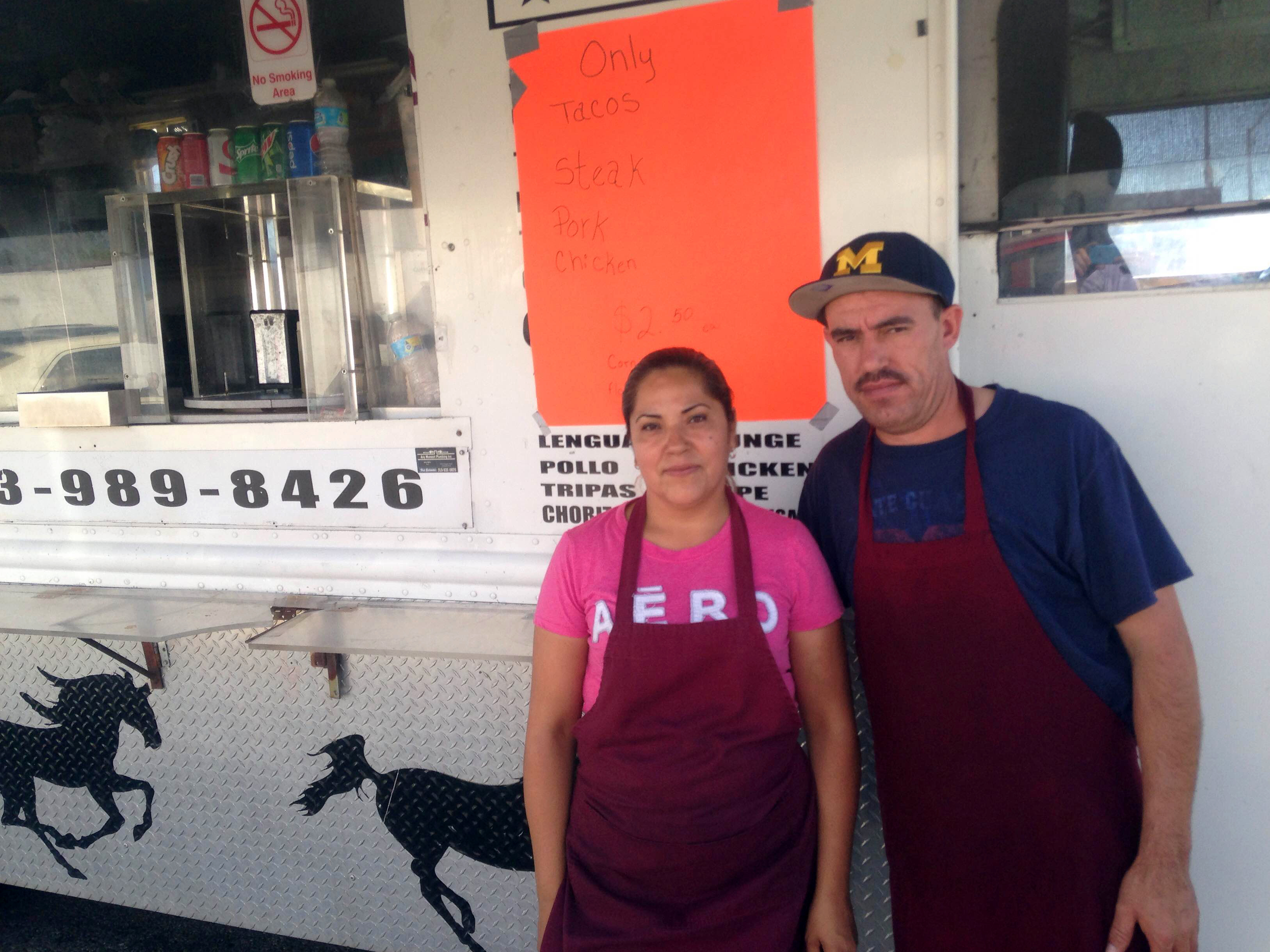 Nancy Paz and Jose Badajoz stand in front of their taco truck, which they positioned near the church Donald Trump visited Saturday morning.