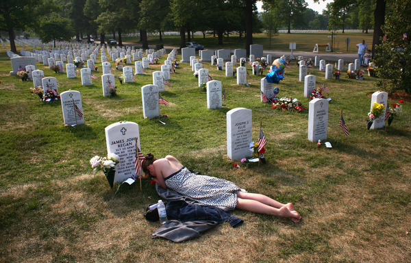 Mary McHugh mourns her slain fiance, Sgt. James Regan, at Arlington National Cemetery in 2007. Regan, a U.S. Army Ranger, was killed by a bomb in Iraq earlier that year. Nearly 7,000 U.S. military personnel have been killed and more than 50,000 wounded in the past 15 years of war.