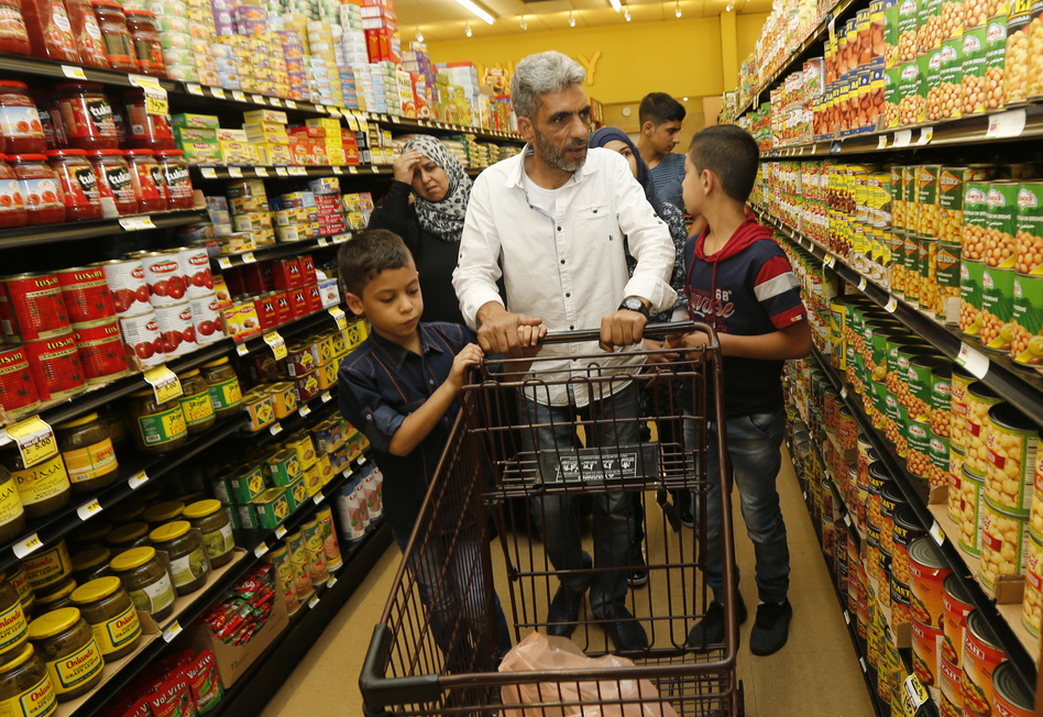 Nadim Fawzi Jouriyeh, a Syrian refugee who arrived in the United States in August with his family, pushes a shopping cart in El Cajon, Calif. (Lenny Ignelzi/AP)