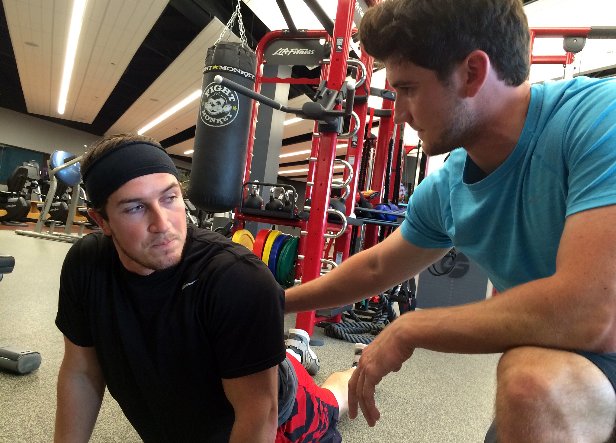 Jake Middleton (right) coaches his brother, Justin, on the cobra pose, which he says can help gamers improve their posture. (KCUR)