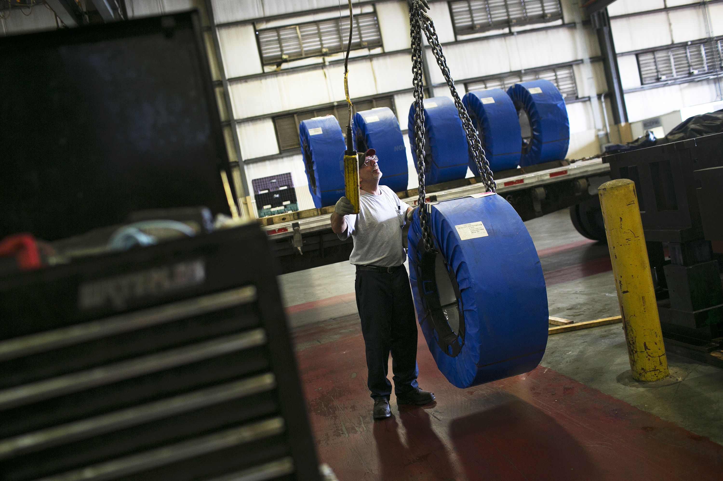 Darren Holly steers coils of steel through Pentaflex, a manufacturer of parts for heavy trucks, in Springfield, Ohio. (Maddie McGarvey for NPR)