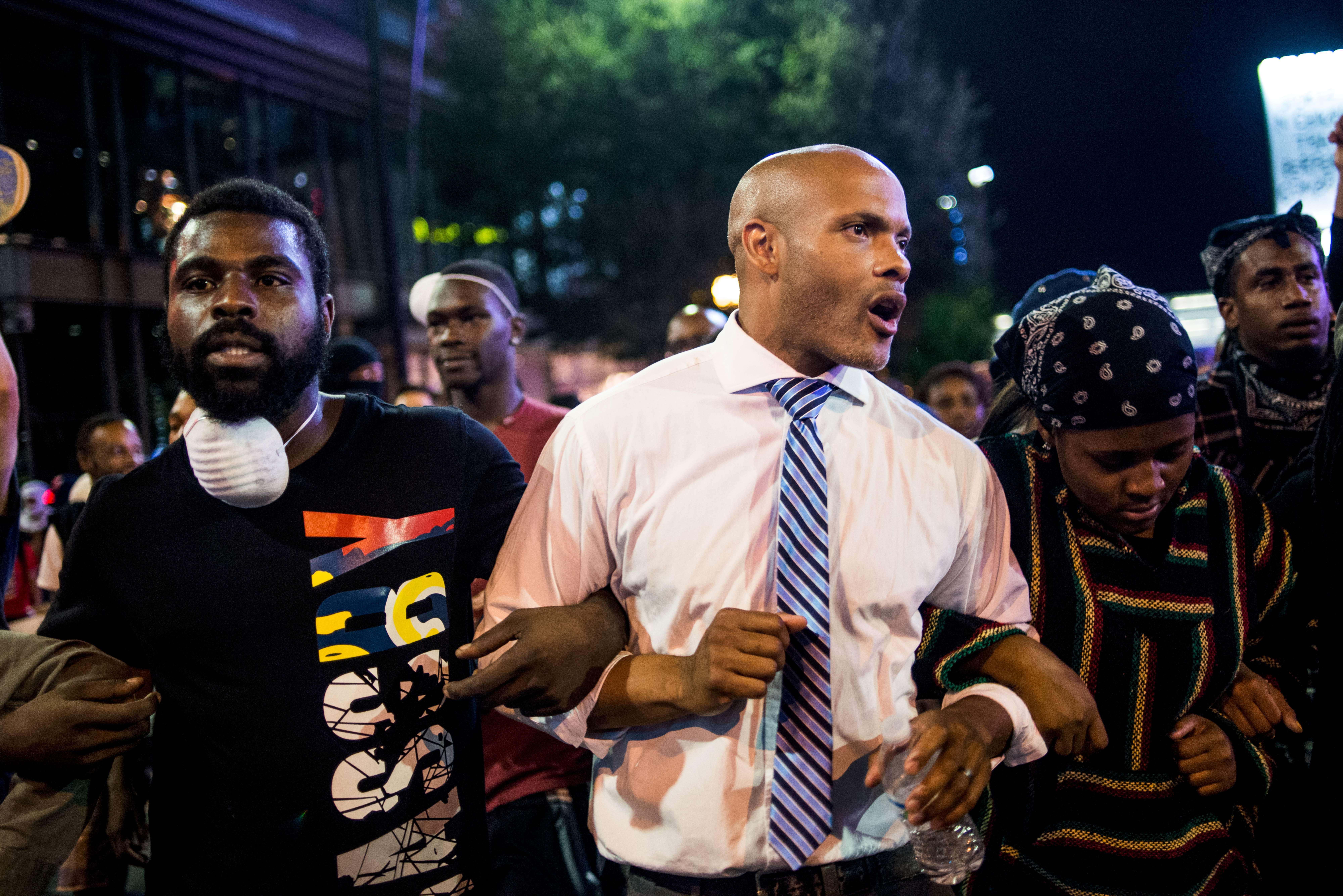 Protesters, including public defender Toussaint Romain (center), march in the early hours of Friday in Charlotte, N.C. Despite a midnight curfew, police allowed the peaceful march to continue without interference. Protests began on Tuesday night following the fatal shooting of 43-year-old Keith Lamont Scott. (Getty Images)