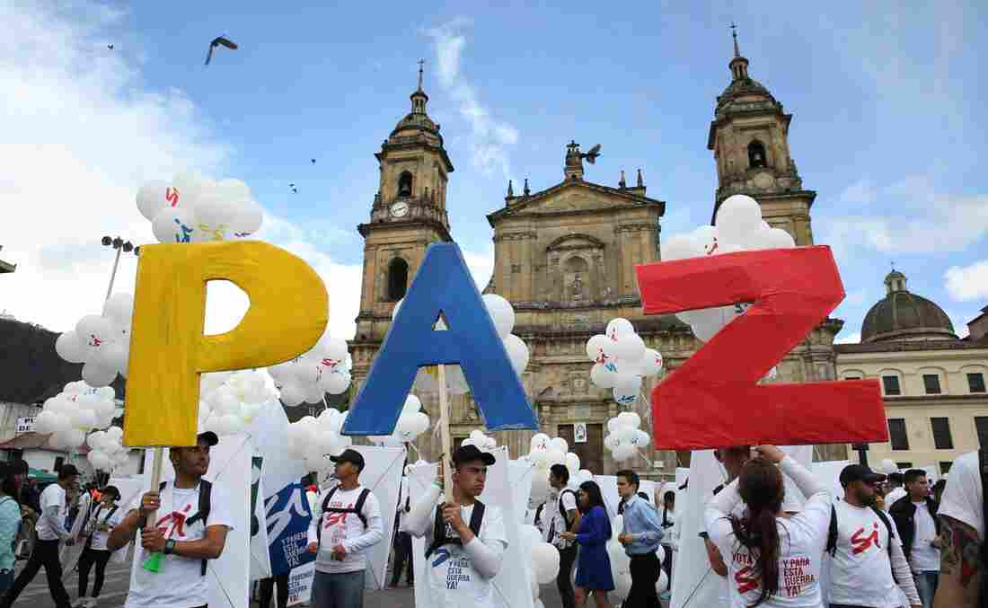 Colombians in the capital, Bogota, hold up the letters for "peace" in Spanish on Monday. The Colombian government and FARC rebels signed a peace agreement, marking an end to the last war in the Western Hemisphere. Colombia's civil war lasted more than 50 years and Latin America has had civil wars for the past six decades. photo: Jennifer Alarcon/AP
