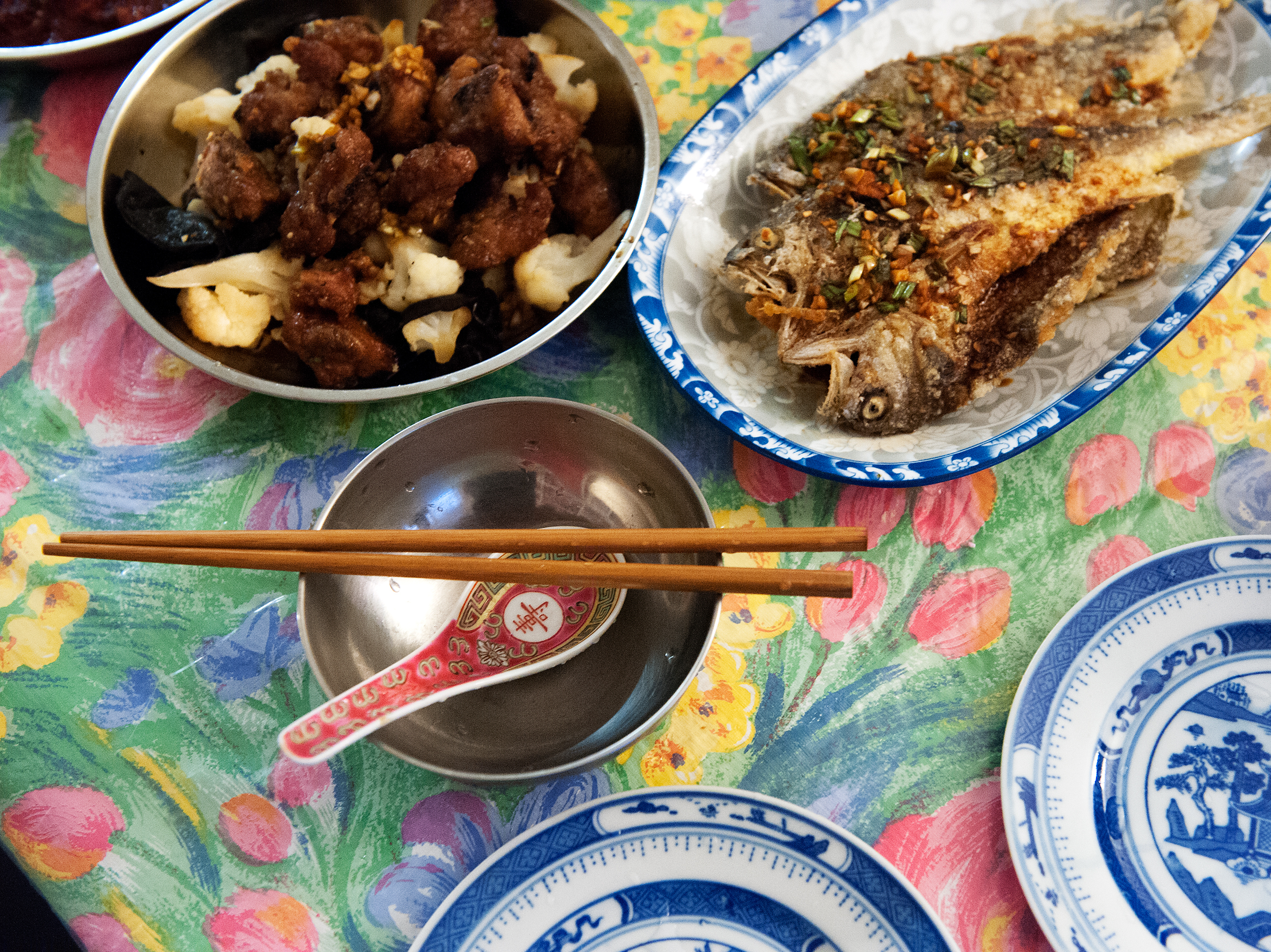 Plates of drunken pork ribs and deep-fried yellow croaker with savory soy sauce fill the dining table of Ni's home in New York City. Bryan Thomas for NPR