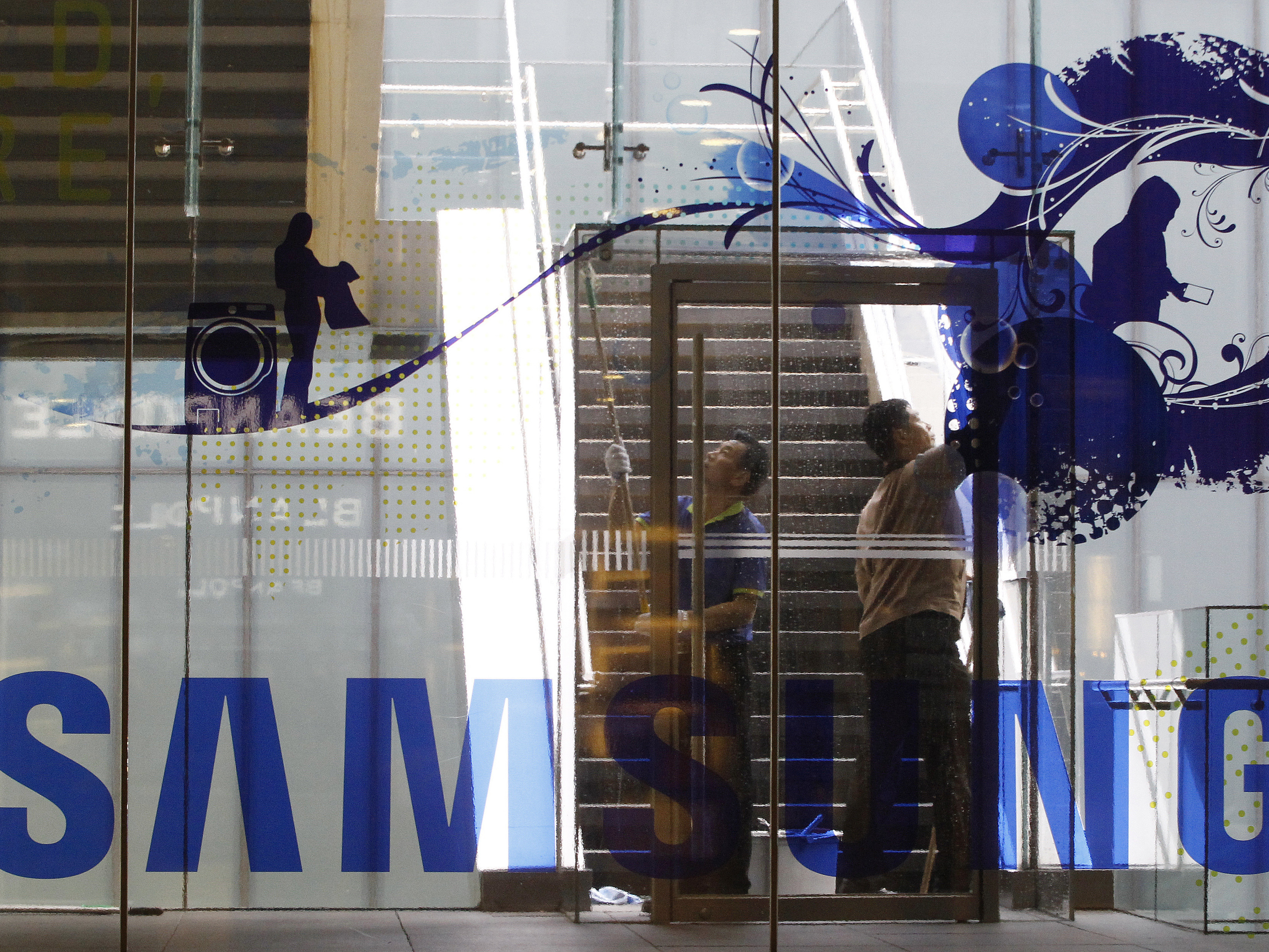 Workers wash a window at a Samsung shop in Seoul, South Korea, on Wednesday as the corporation works out how to clean up its sullied reputation.