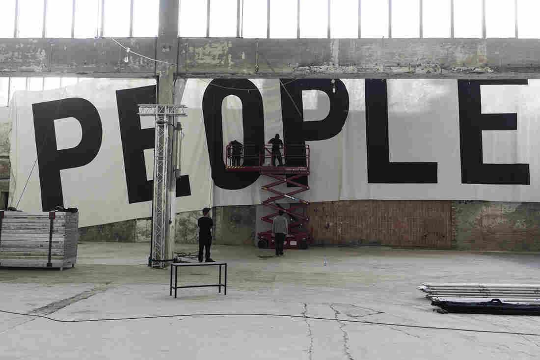 Workers hang a banner at the Funkhaus in Berlin.