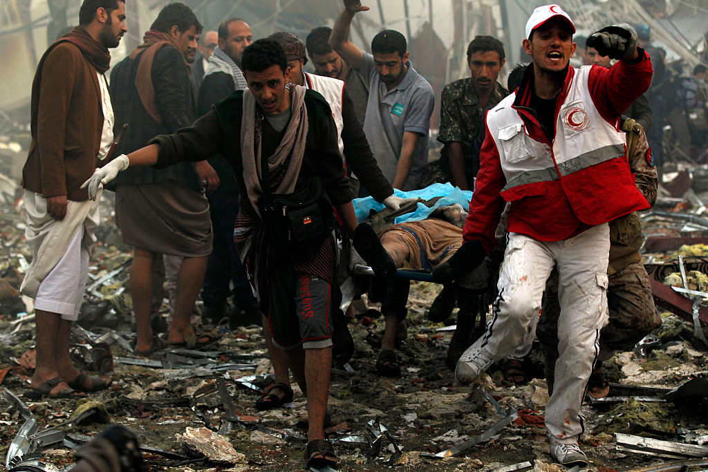 Yemeni rescue workers carry a victim on a stretcher amid the rubble of a destroyed funeral hall building following airstrikes by Saudi-led coalition planes on the capital Sanaa last Saturday.