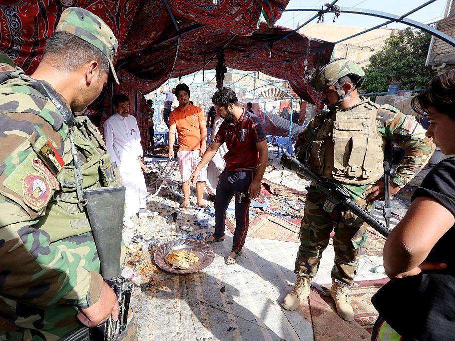 Iraqi soldiers and civilians inspect the damage at the site of a suicide bombing that targeted Shiite Muslims on Saturday in the Shaab area of the Iraqi capital Baghdad. (AFP/Getty Images)