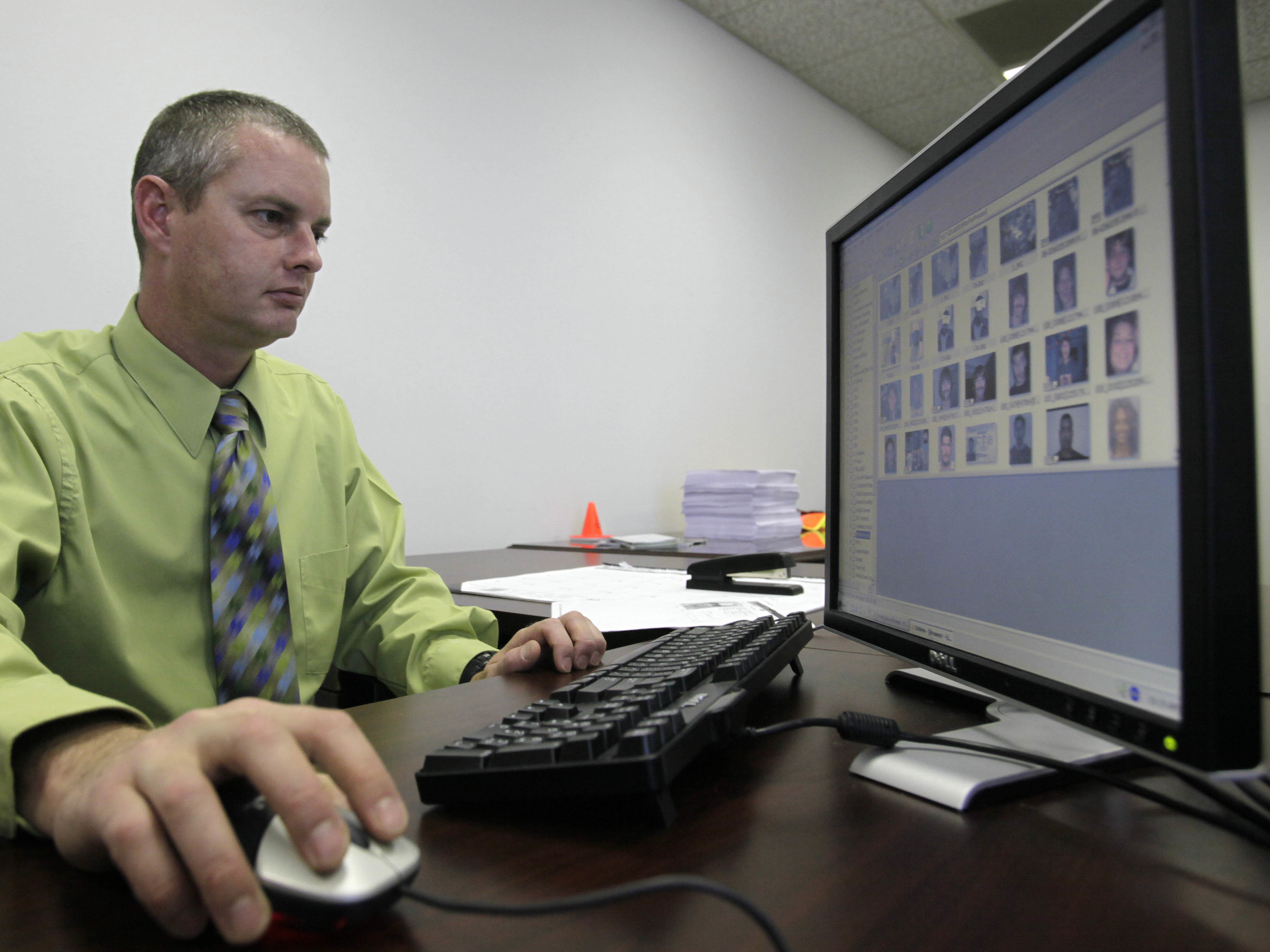 Stephen Lamm, a supervisor with the ID fraud unit of the North Carolina Department of Motor Vehicles, looks through photos in a facial recognition system in 2009 in Raleigh, N.C.