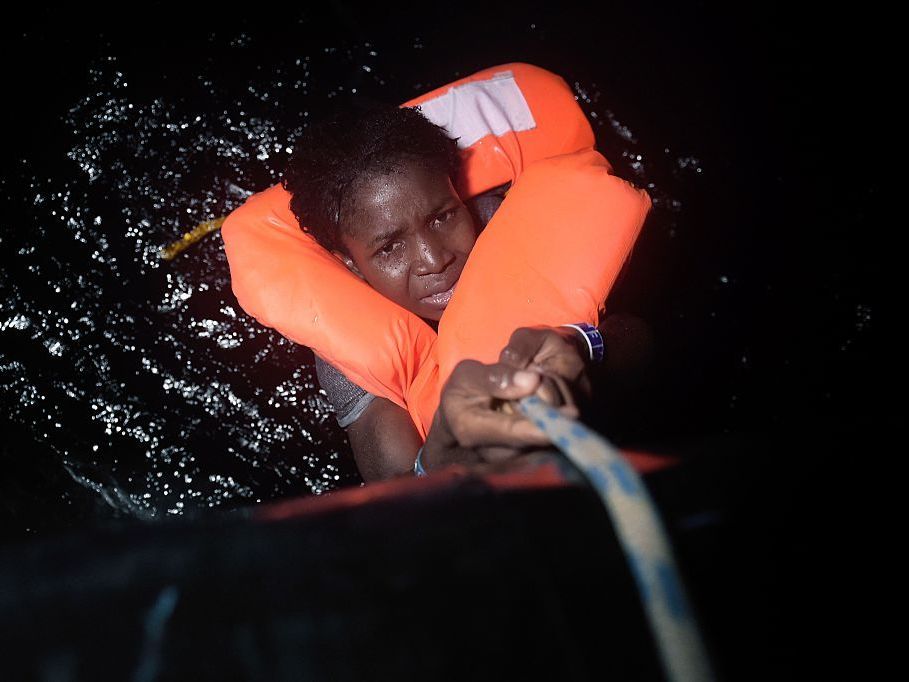 A migrant holds onto a rope during a rescue operation some eight nautical miles off Libya's Mediterranean coastline earlier this month.