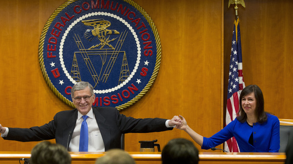 Federal Communication Commission Chairman Tom Wheeler joins hands with Commissioner Jessica Rosenworcel ahead of a February 2015 hearing in Washington, D.C.