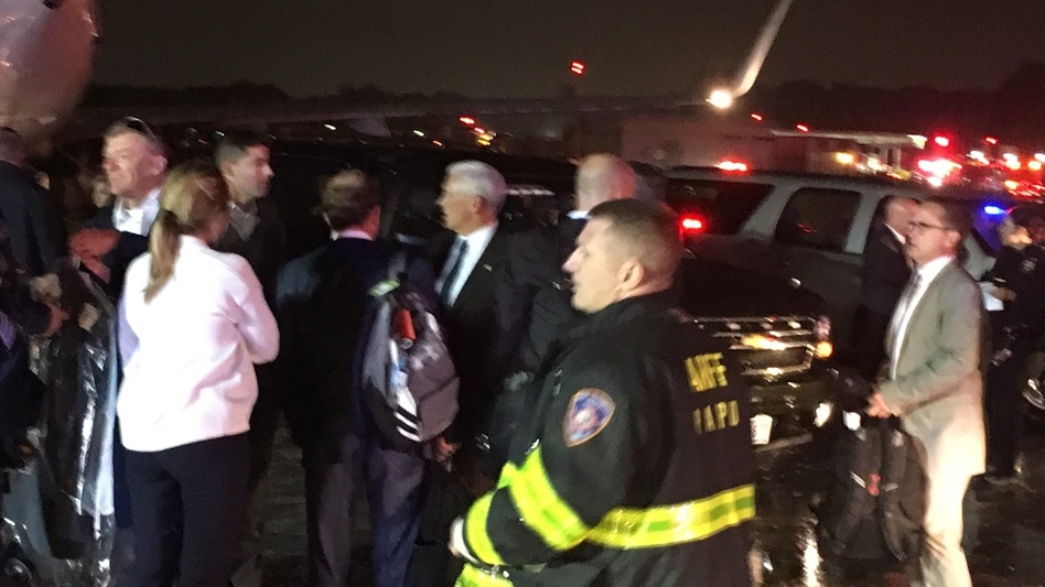 Republican presidential candidate Indiana Gov. Mike Pence (center) talks on the tarmac at New York City's LaGuardia Airport after his campaign plane slid off the runway while landing Thursday.