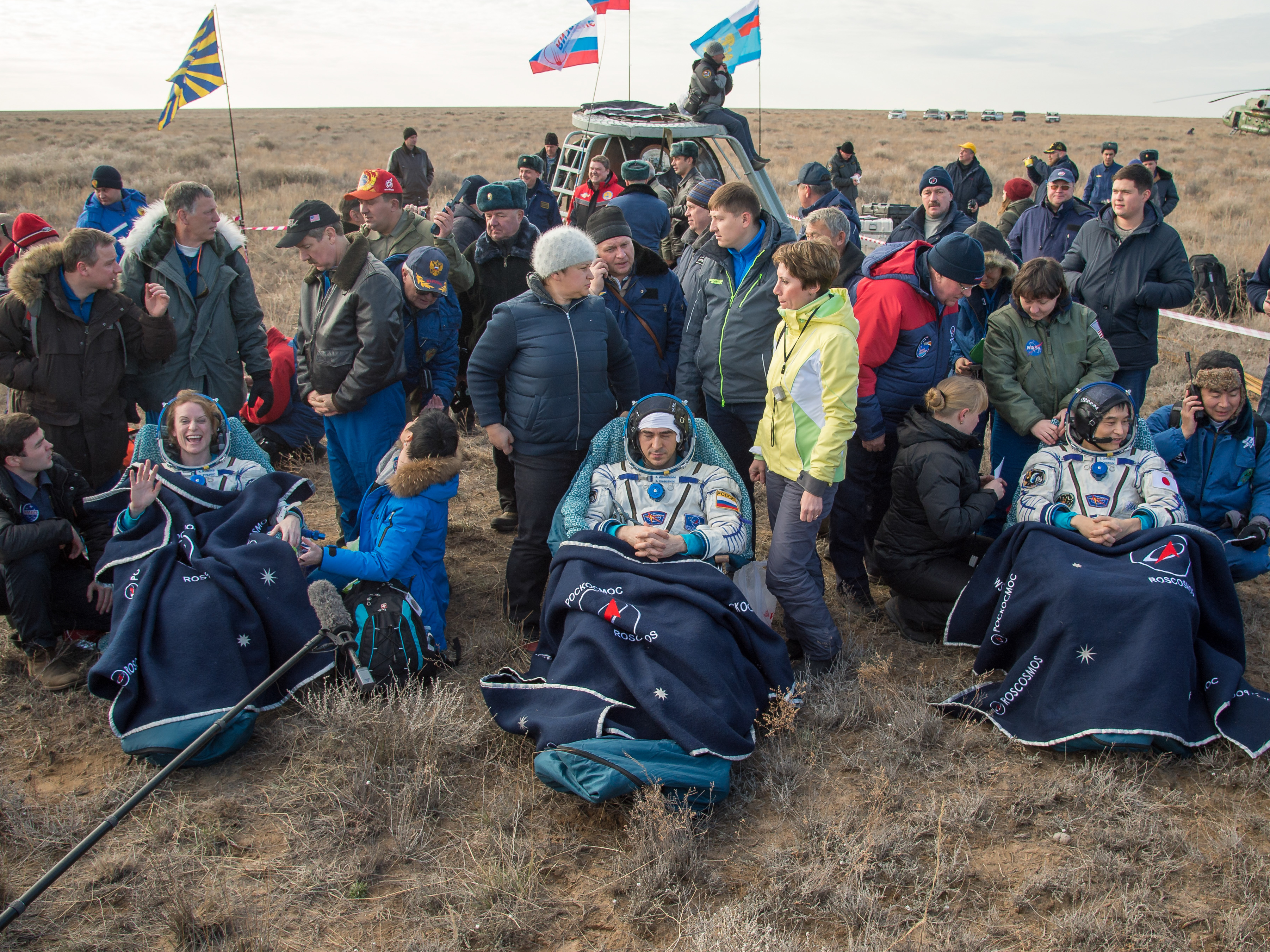 NASA astronaut Kate Rubins, left, Russian cosmonaut Anatoly Ivanishin of Roscosmos, center, and astronaut Takuya Onishi of the Japan Aerospace Exploration Agency sit outside the Soyuz MS-01 spacecraft a few minutes after they touched down on earth Sunday. Bill Ingalls/NASA.