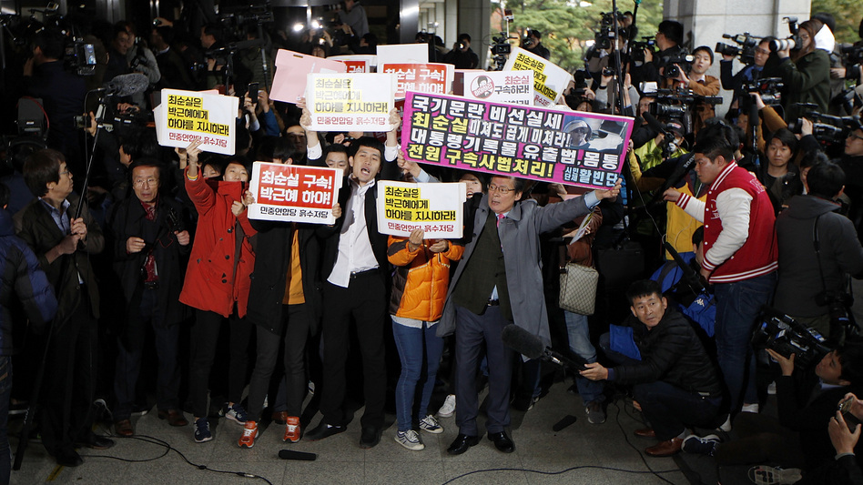 Anti-government protesters demonstrate as Choi Soon-sil, a confidante of South Korean President Park Geun-hye, appears at the Seoul Central Prosecutors' Office on Monday. (Woohae Cho/Getty Images)