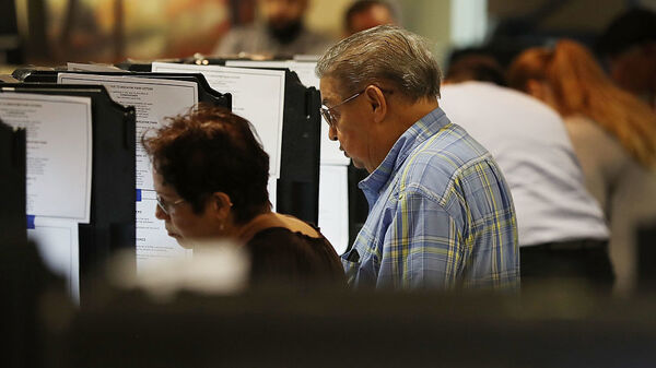 Voters cast their votes at an early voting center in Miami, Fla.