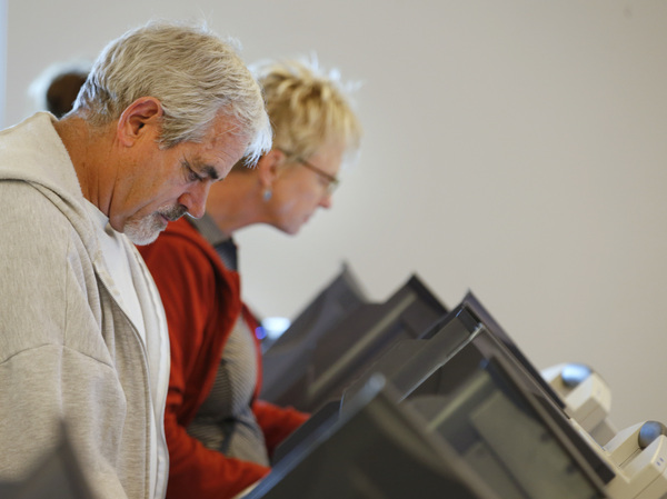 People cast their ballots on electronic voting machines at the Provo Recreation Center on Oct. 25, the first day of early voting in Provo, Utah.