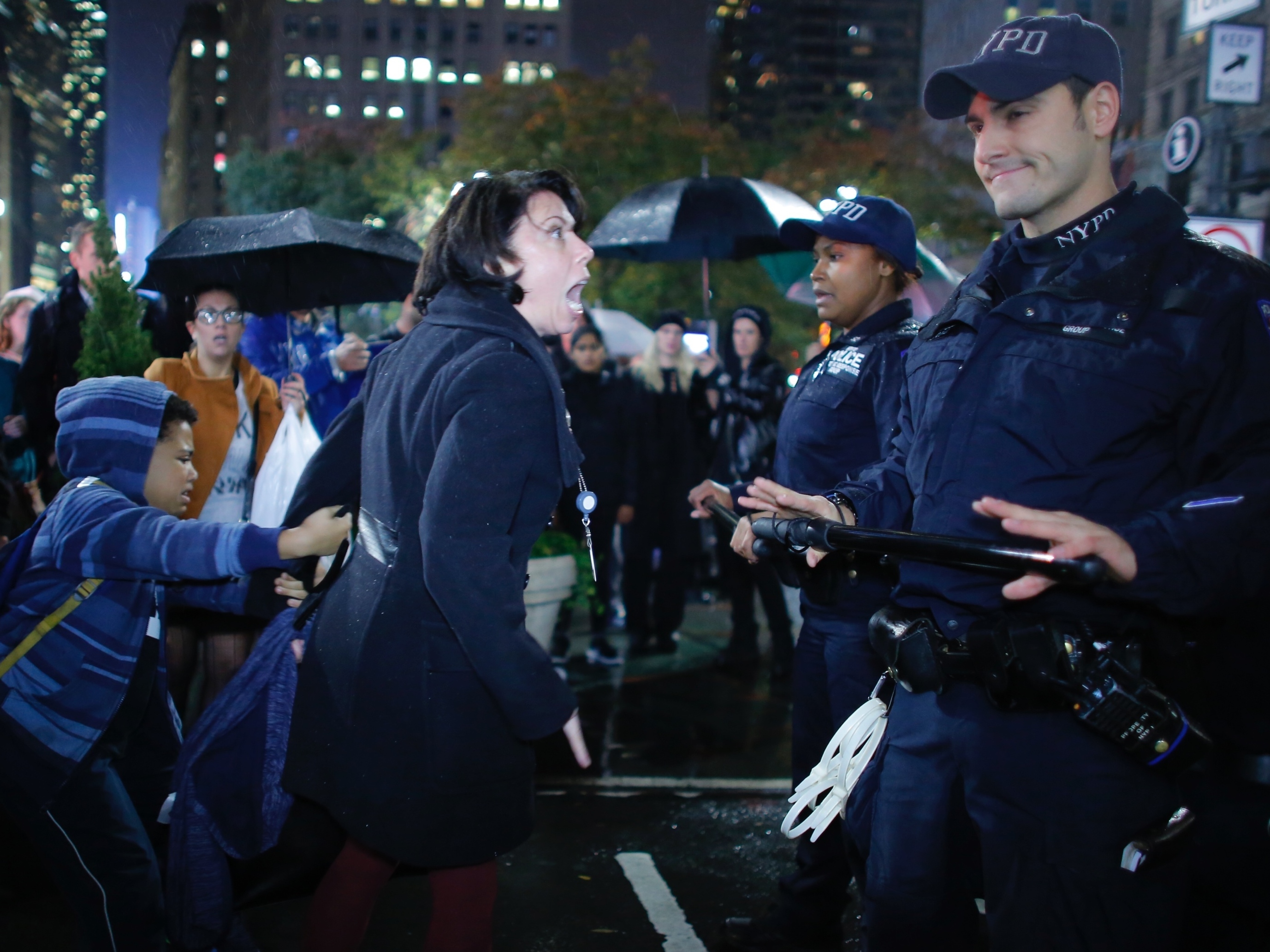 A woman argues with NYPD officers as she takes part in a protest against President-elect Donald Trump in New York City tonight.