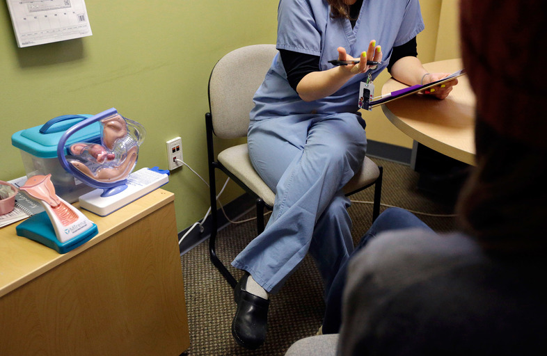 A health care provider interviews a patient at a Planned Parenthood clinic in Boston in 2013. (Steven Senne/AP)